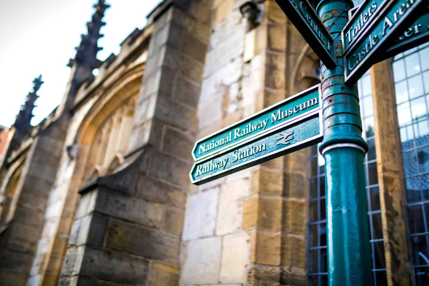 Directional Tourist information and visitor attractions signs to different destinations in the City of York, England, United Kingdom with an historic church in the background